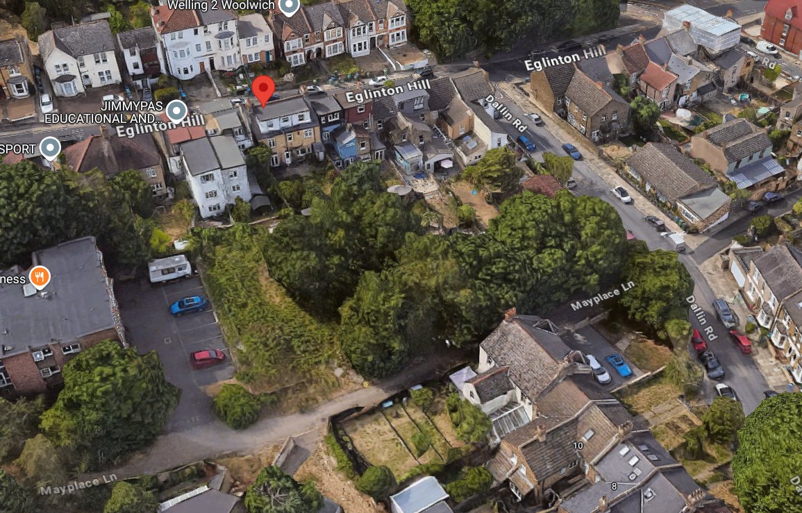 The same land from the air. The houses fronting Eglinton Hill run along the top, and the site is the block of mature trees and undergrowth behind them.