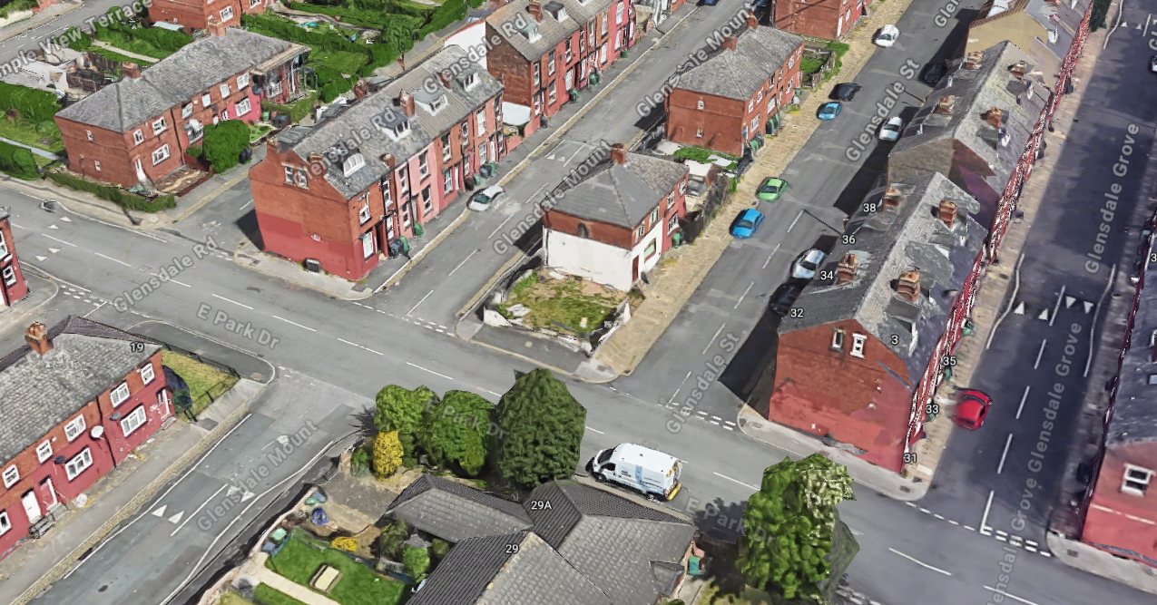 The same corner from the air. The site is the vacant grassed plot beside the rendered end house, hemmed in by Glensdale Street, Glensdale Mount and East Park Drive. Note the red brick two-storey terraces running away in every direction.